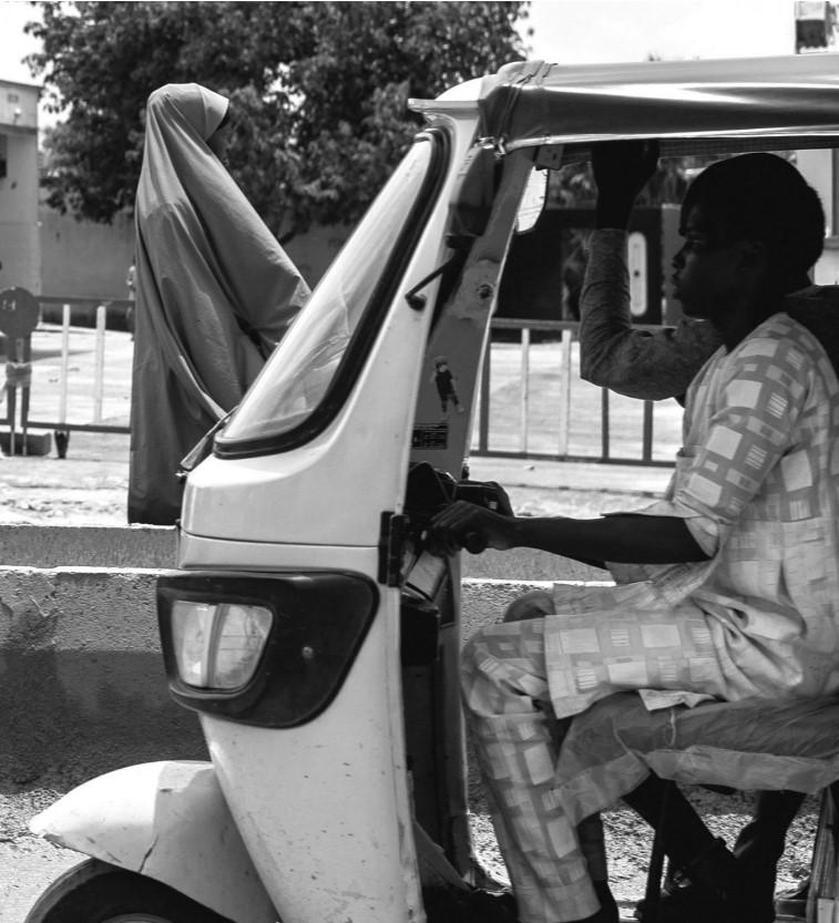 A keke drives past a woman outside Bakassi Camp before its closure in December. Source: Nigeria Analysis Team